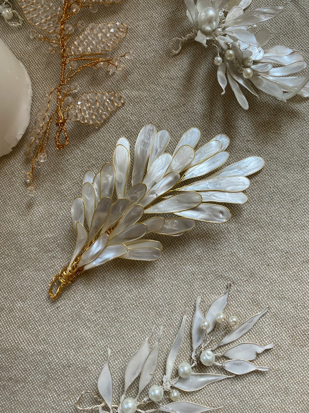 Handcrafted bridal hair accessories arranged on light beige fabric.