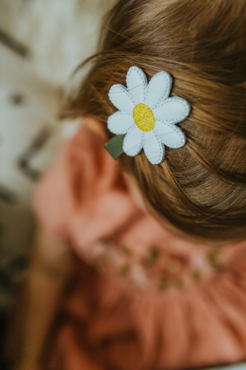 Daisy hair clip resting in light brown hair.